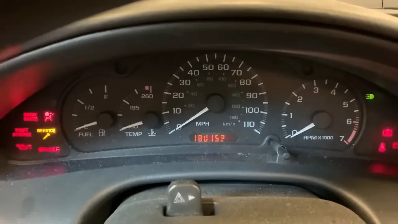 Car instrument cluster with speedometer, tachometer and illuminated warning lights at idle