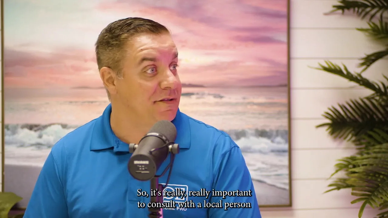 man in blue polo speaking into microphone with beach painting background, subtitle: