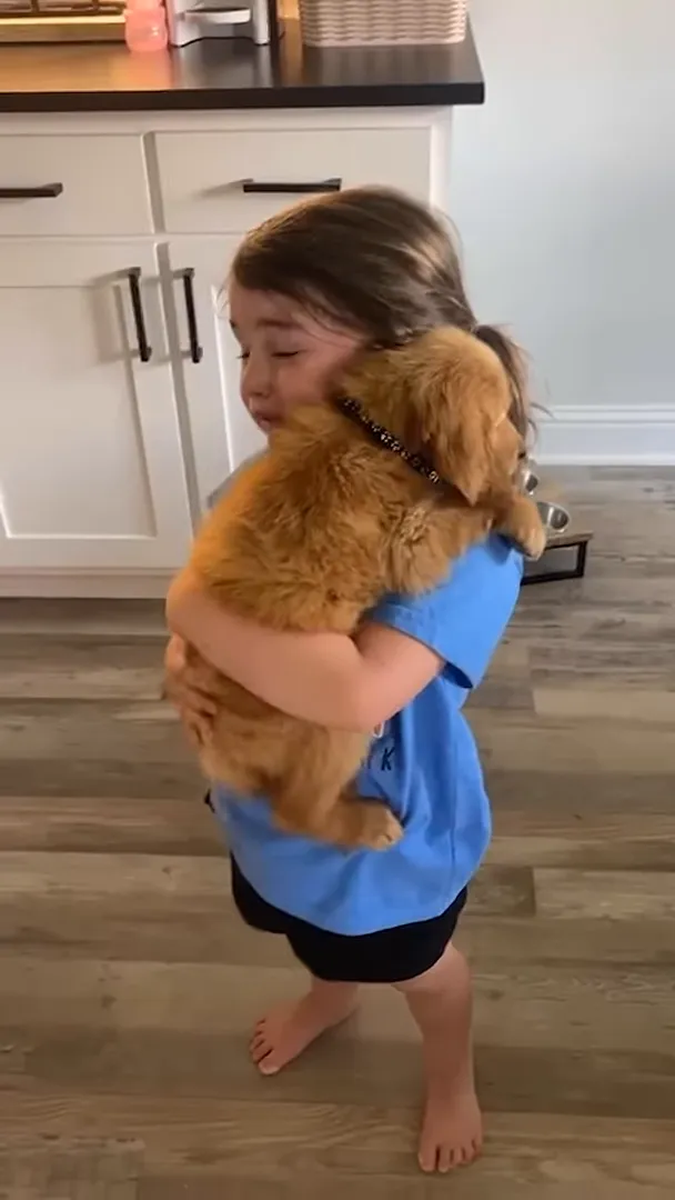 Little girl holding her new puppy, crying tears of joy