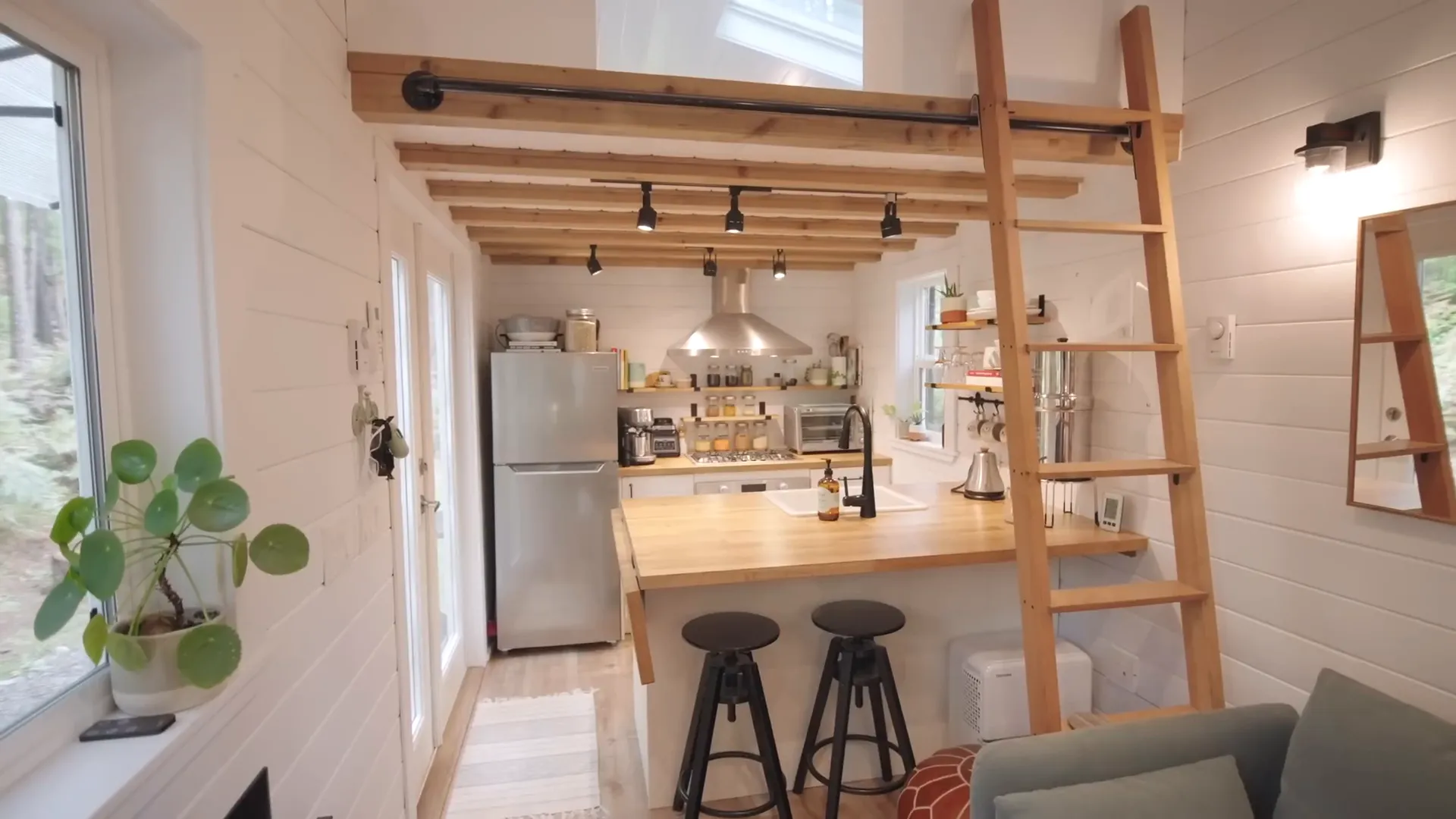 Amber in her open kitchen with shelves filled with dishes.