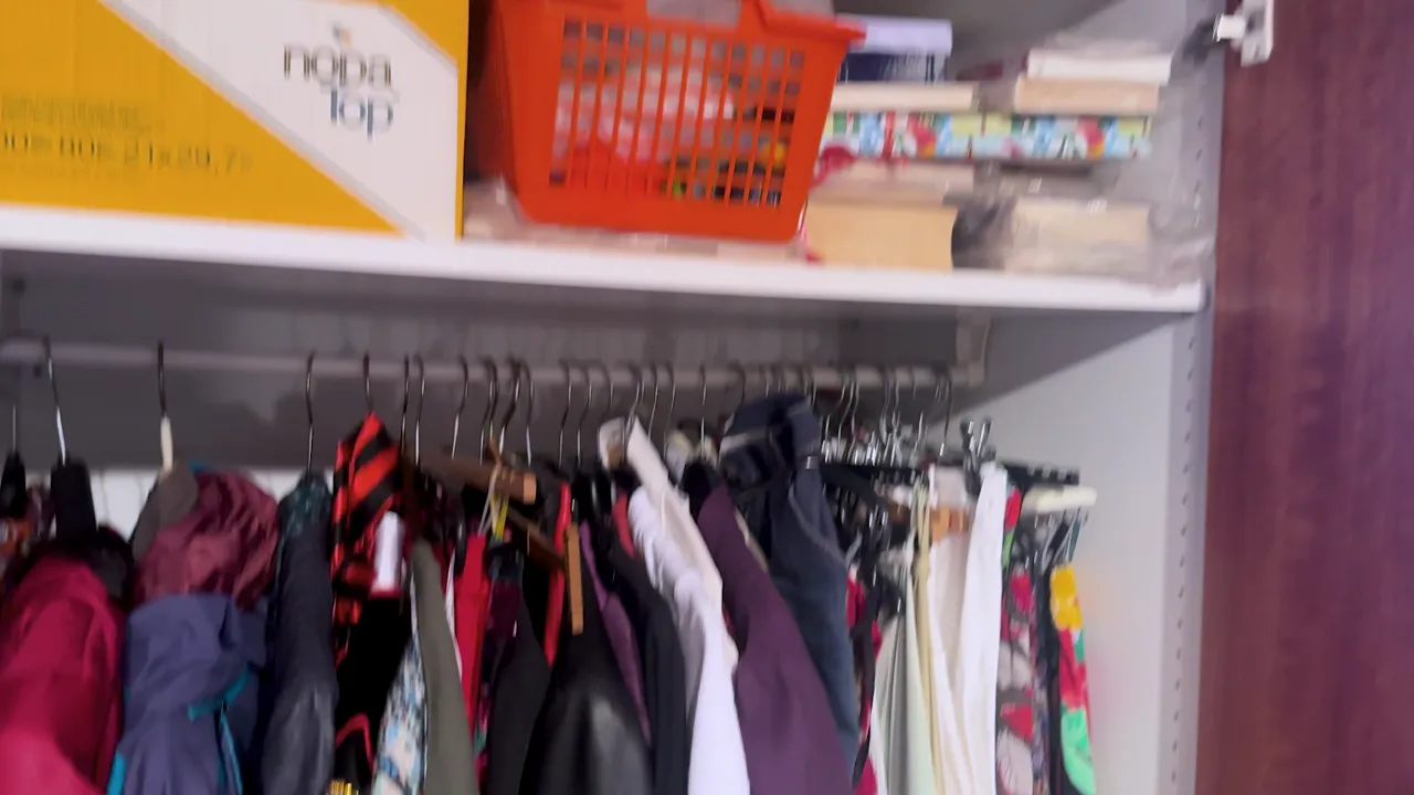 Überfüllter Kleiderschrank mit dicht hängender Kleidung und Kisten