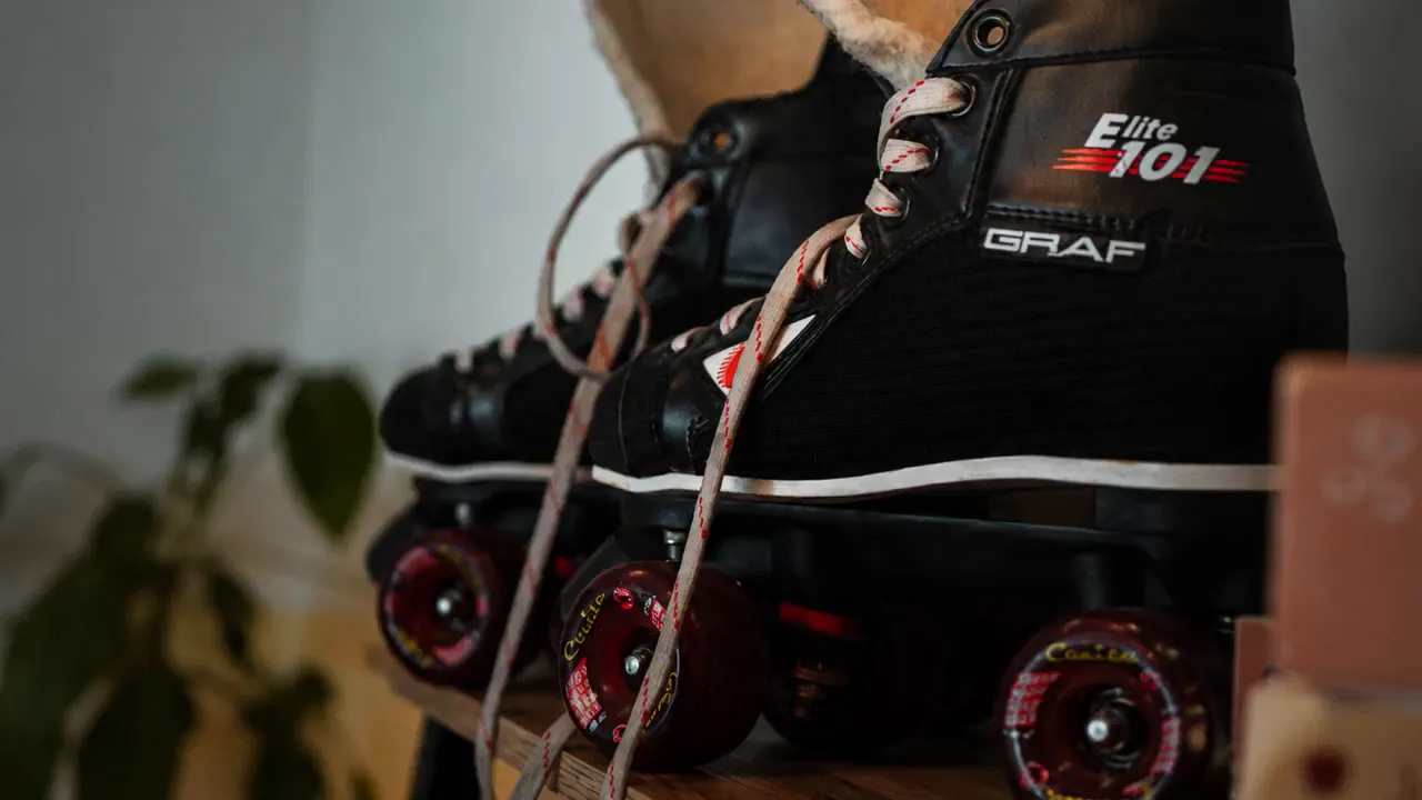 Alte Rollschuhe mit schwarzen Schuhen und roten Rollen