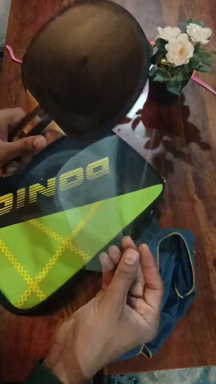 Transparent plastic sheet held in front of a black table tennis rubber