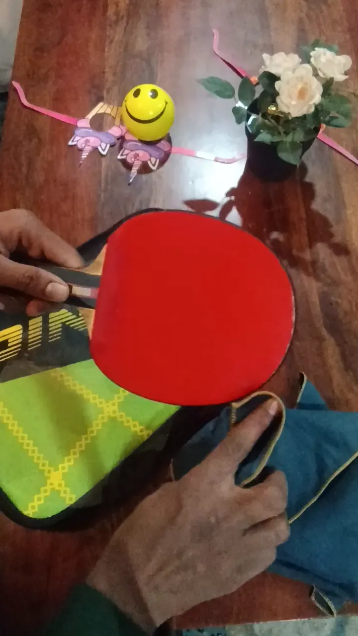 Red table tennis rubber being wiped with a blue cloth