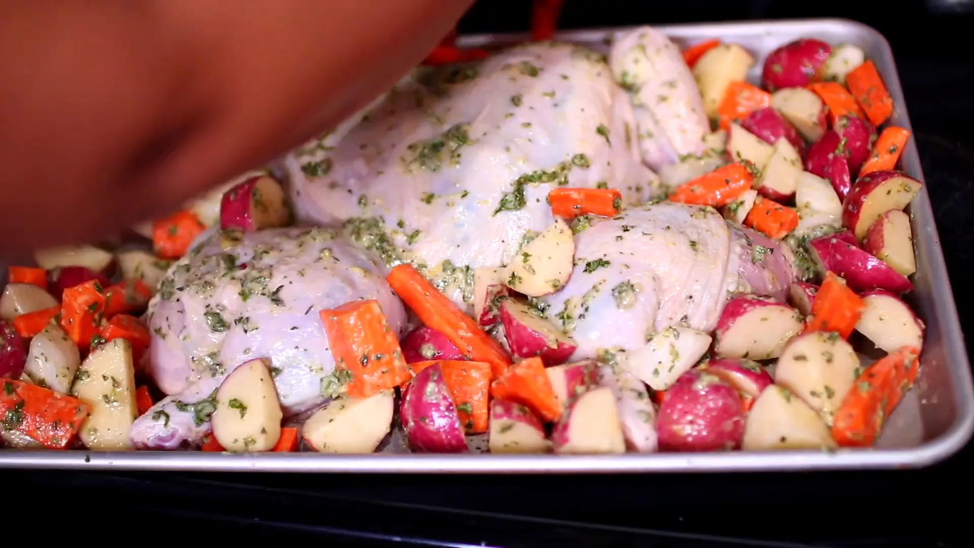Arranging chicken and vegetables on the baking pan