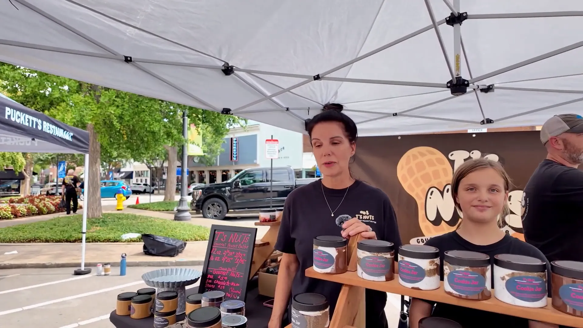 Local baker at the farmers market handing a sample to a visitor