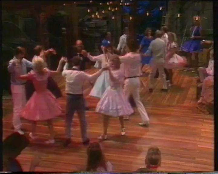 Fyra damer dansar i cirkel med traditionella danssteg