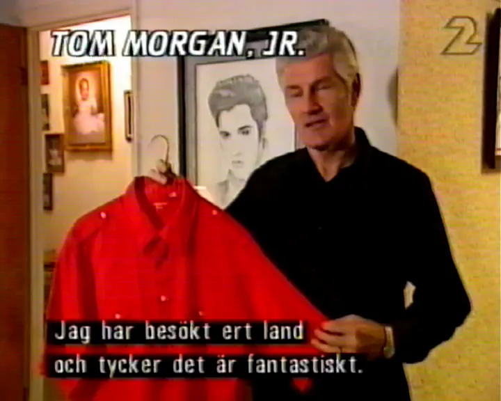 Tom Morgan presenterar en Elvis-tröja för välgörenhetsauktion