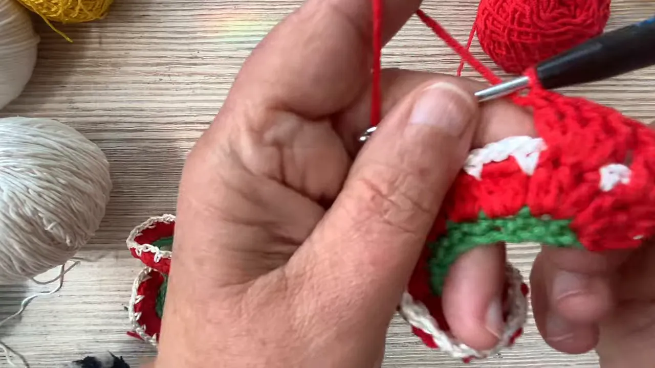 Close-up of red crochet fabric with small white dots above a green foundation