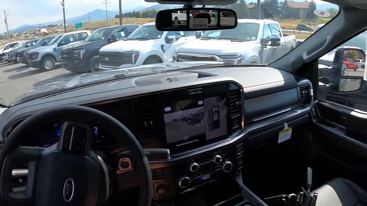Wide interior view of Ford F-350 Lariat showing central touchscreen with 360 camera, digital instrument cluster and climate control knobs
