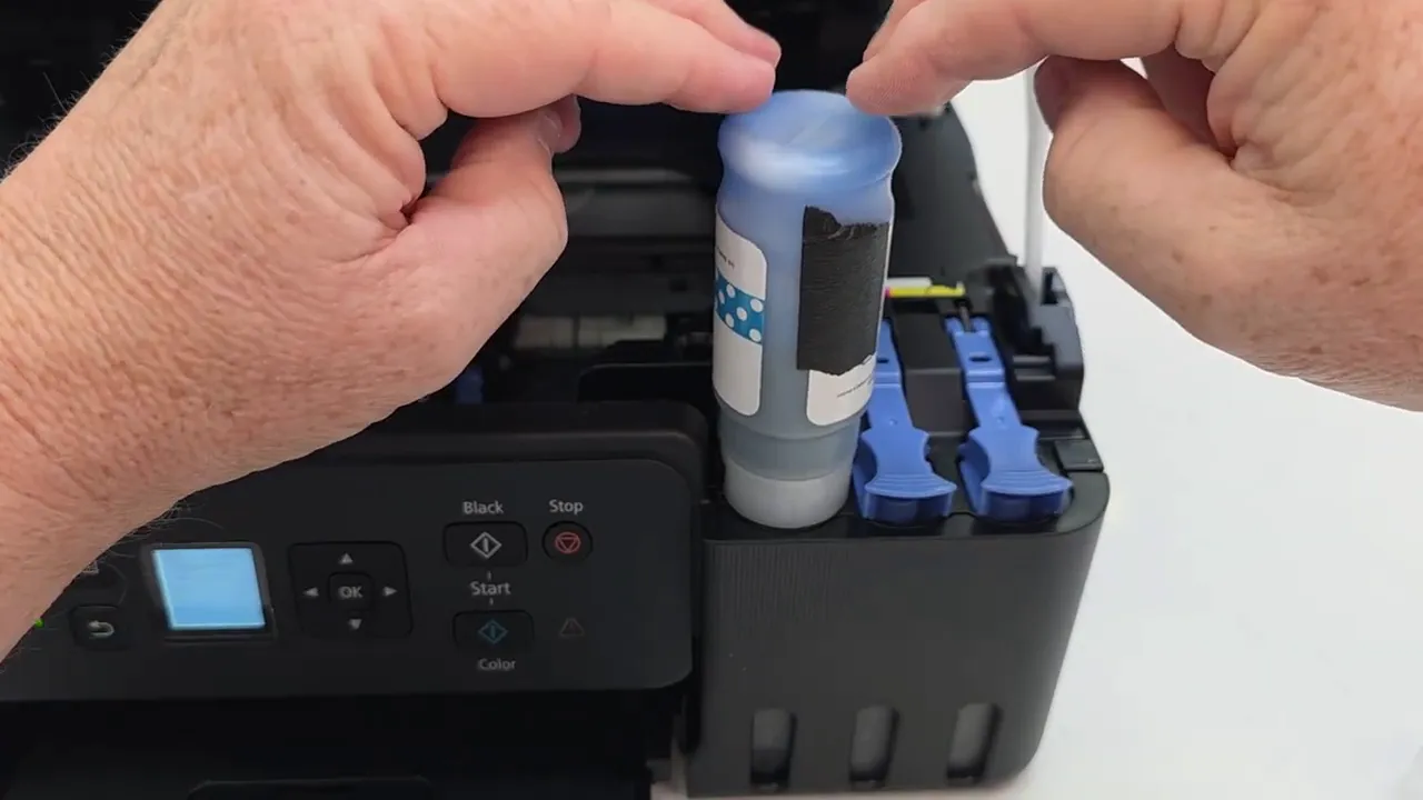 Inserting cyan ink bottle into the tank and hearing gurgling as it fills