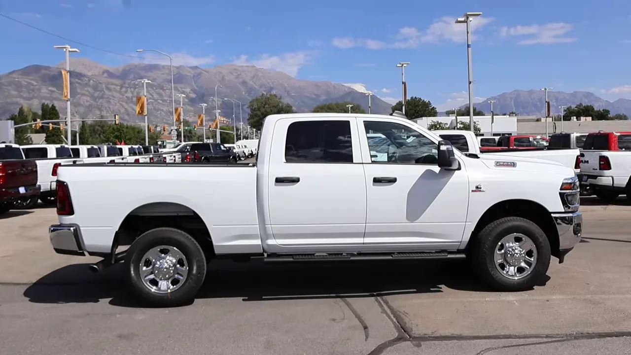 Clear side view of white Ram 2500 crew cab with chrome wheels and running boards