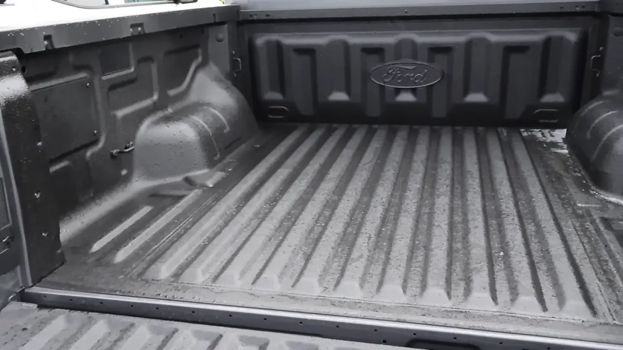 Ford Ranger truck bed with spray-in liner and Ford emblem on the front of the bed.