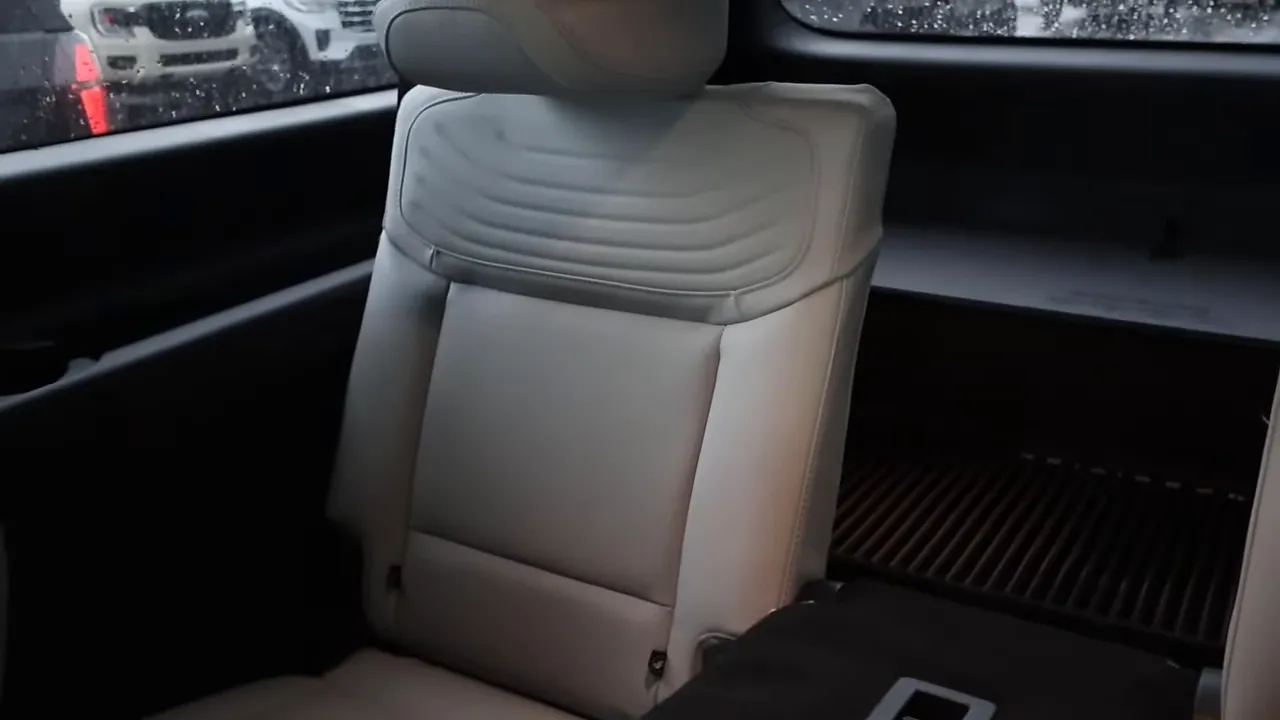 Third-row seat and rear cargo area of a full-size SUV showing seatback, window and cargo floor.