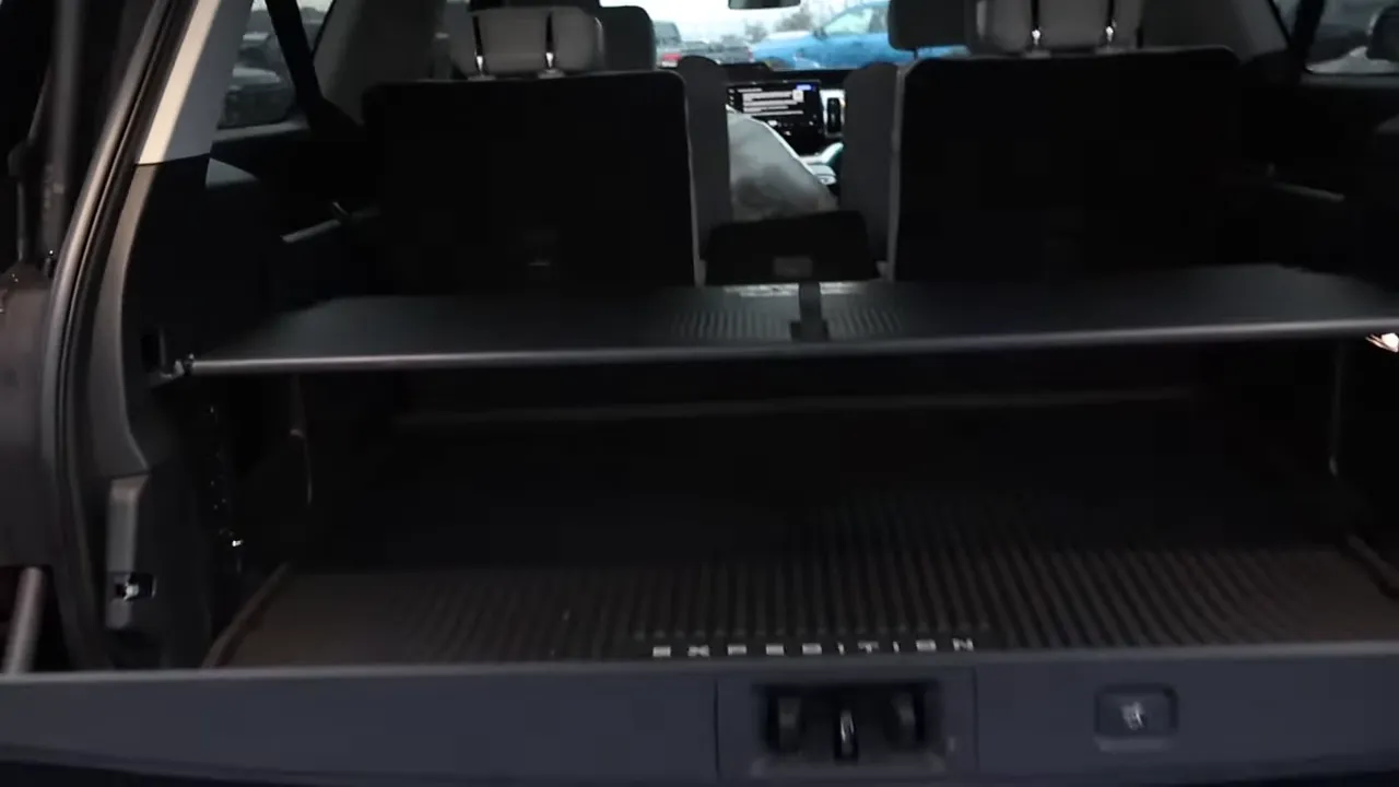 Open Ford Expedition cargo area with lower tailgate down, cargo cover extended and EXPEDITION-branded cargo mat visible