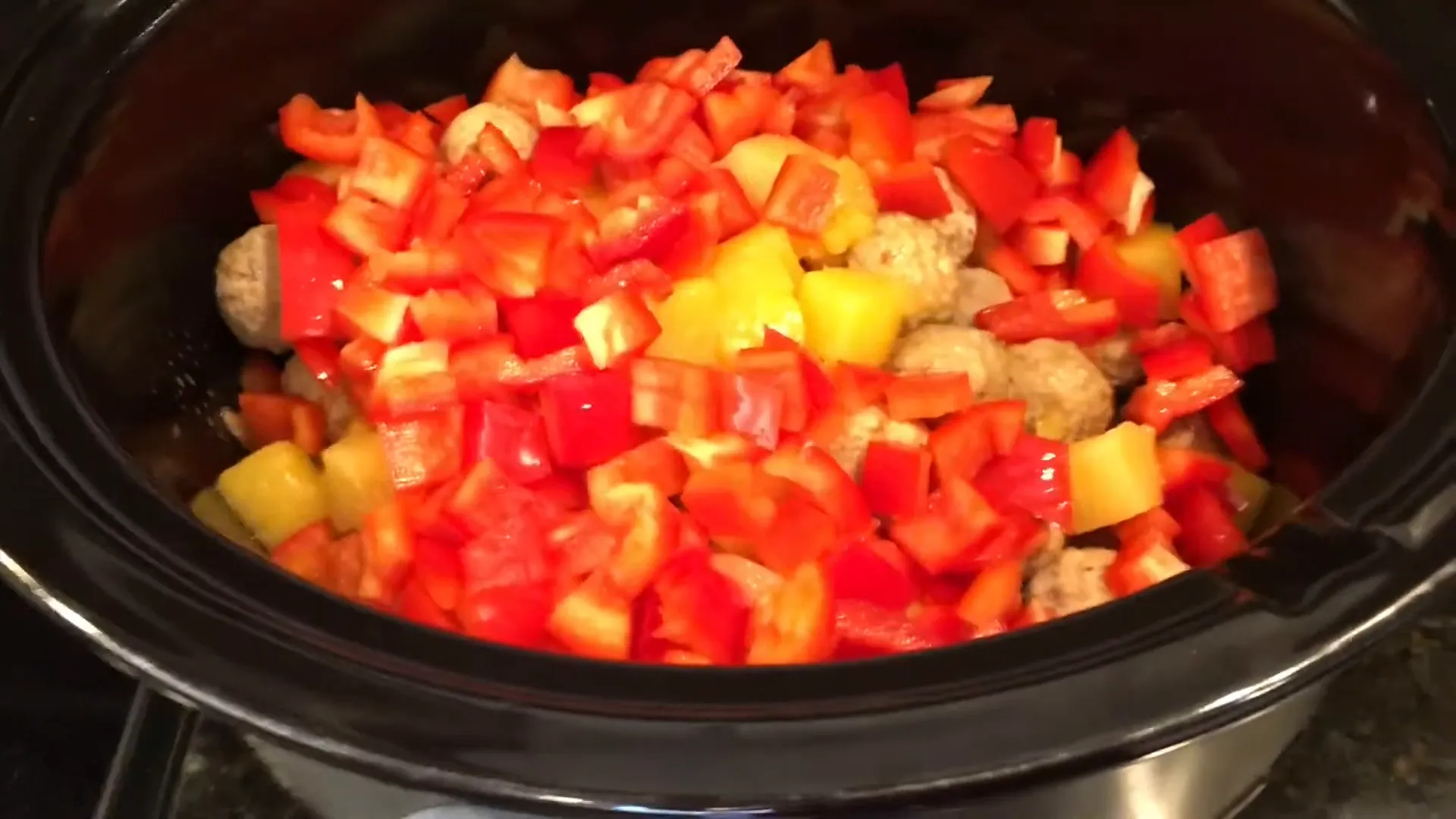 Evenly distributing bell peppers over the meatballs.