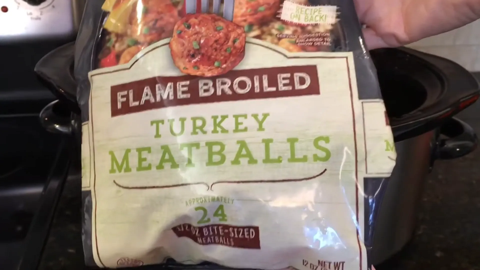 Adding frozen turkey meatballs to the crockpot.