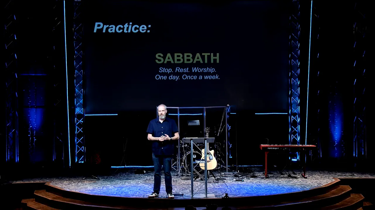 Pastor on a stage with a screen showing the “Practice: SABBATH” framework: “Stop. Rest. Worship. One day. Once a week.”