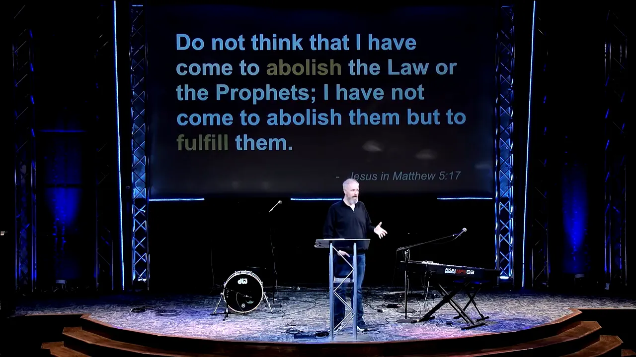 clear image of speaker at lectern under a slide quoting Matthew 5:17 explaining fulfillment of the law