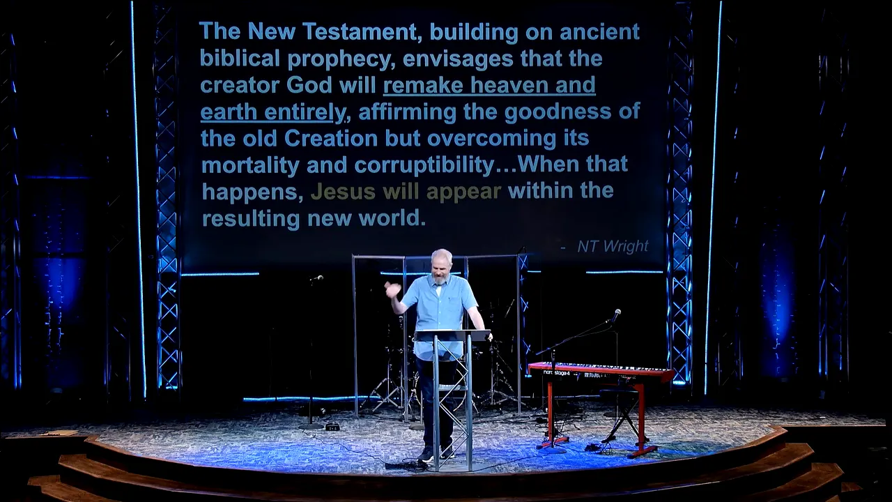 Pastor speaking on a stage while a screen displays text about the new world and renewal