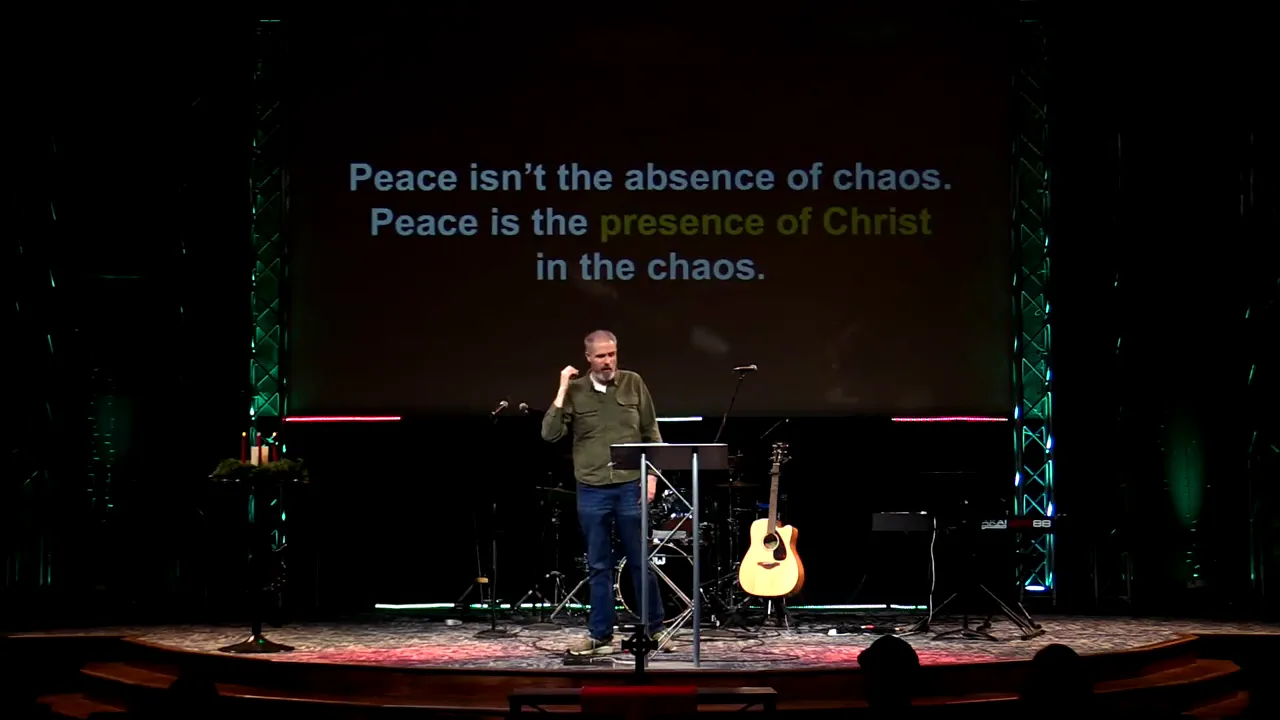 Speaker on stage with slide reading 'Peace isn't the absence of chaos. Peace is the presence of Christ in the chaos.'