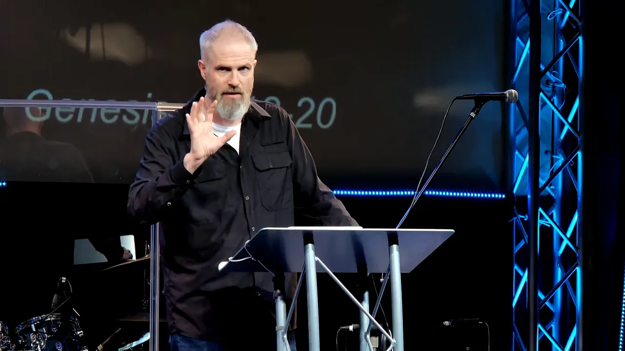 Speaker raising hand while explaining Melchizedek in Genesis