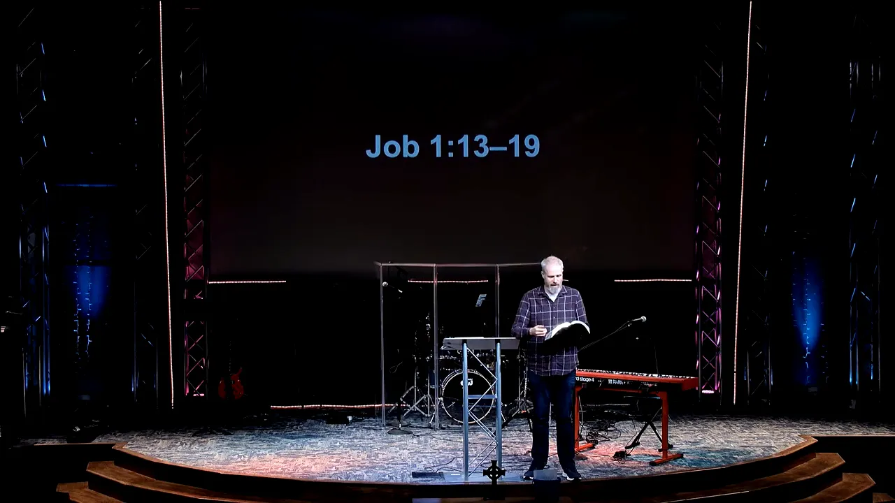 Speaker speaking on stage with Job 1:13–19 displayed