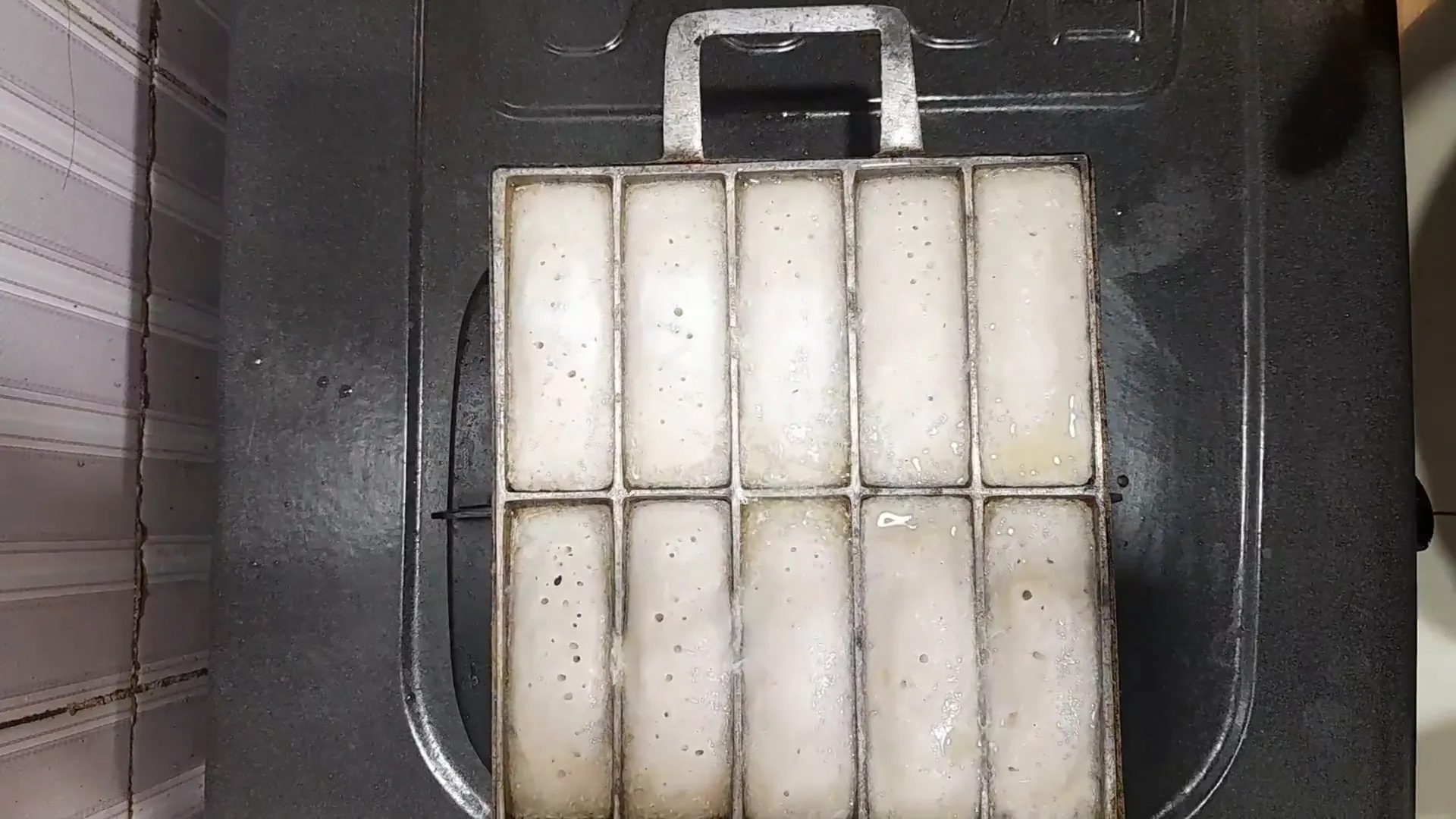 Kue pancong matang dengan lubang kecil dan taburan gula di atasnya