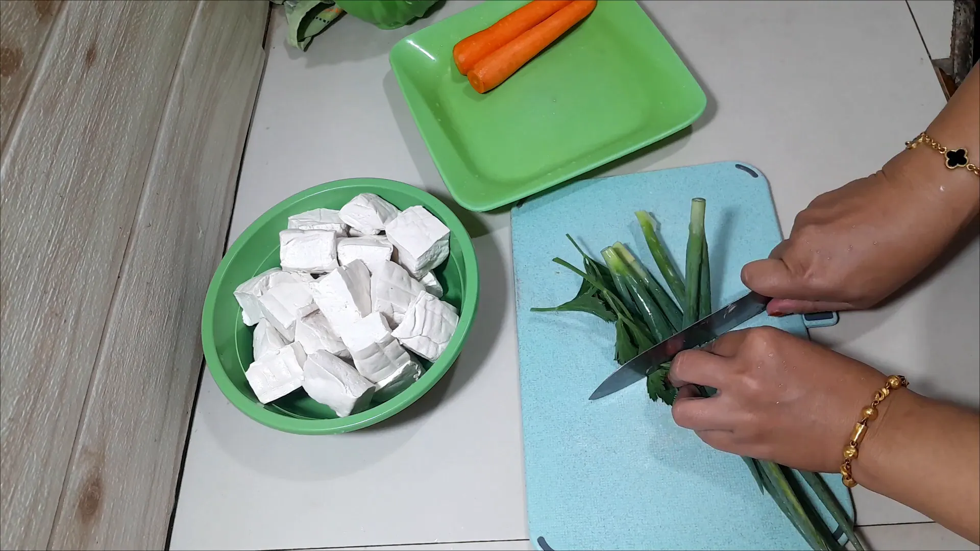 Mengiris daun bawang dan daun seledri serta memarut wortel
