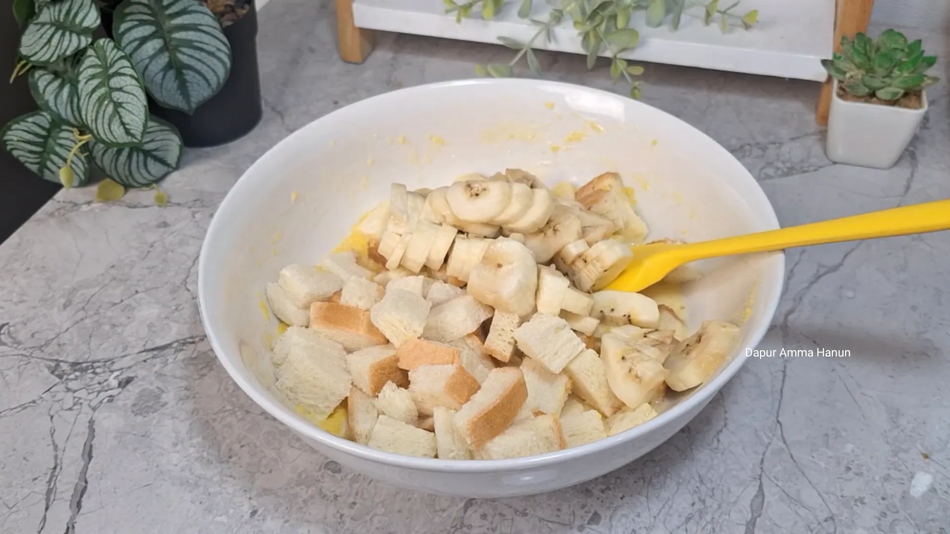 Roti tawar dan pisang dipotong kecil dan dicampur ke dalam adonan