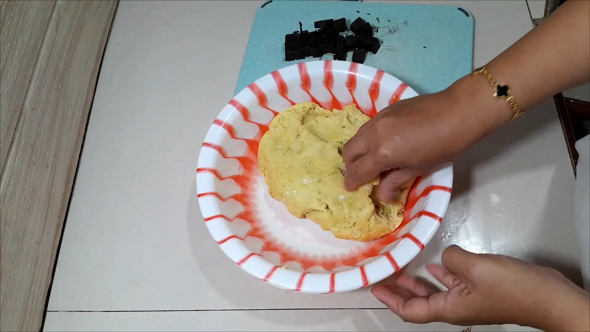 Mencampur adonan ubi jalar dengan kelapa, gula, garam, dan tepung terigu menggunakan tangan