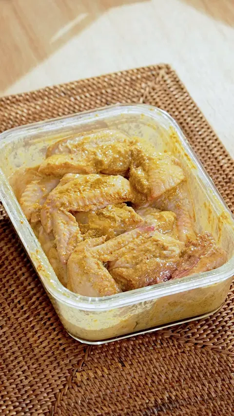Ayam yang sudah dimarinasi dengan bumbu kuning merata