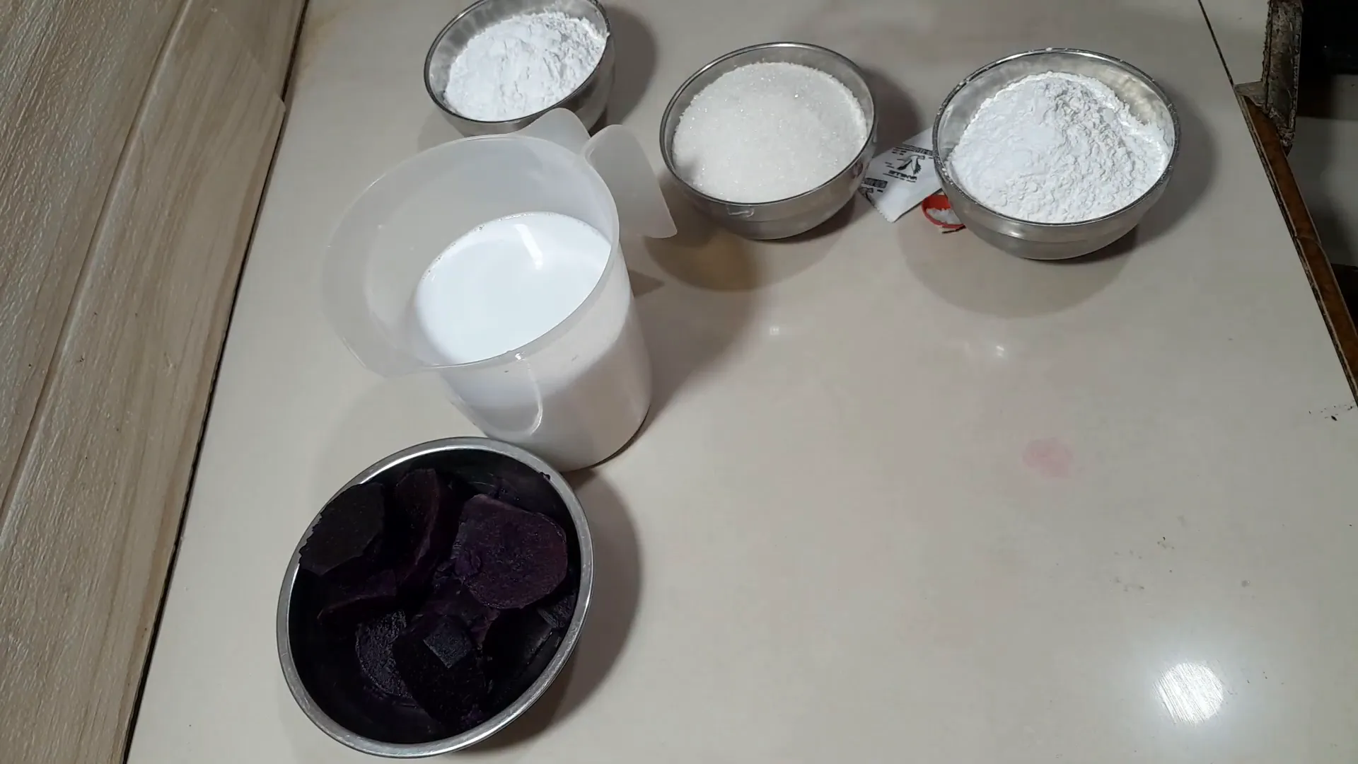 Mengaduk adonan ubi ungu dengan tepung dan bumbu menggunakan whisker