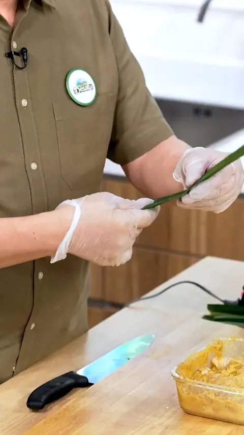 Proses membungkus ayam dengan daun pandan dan membuat simpul