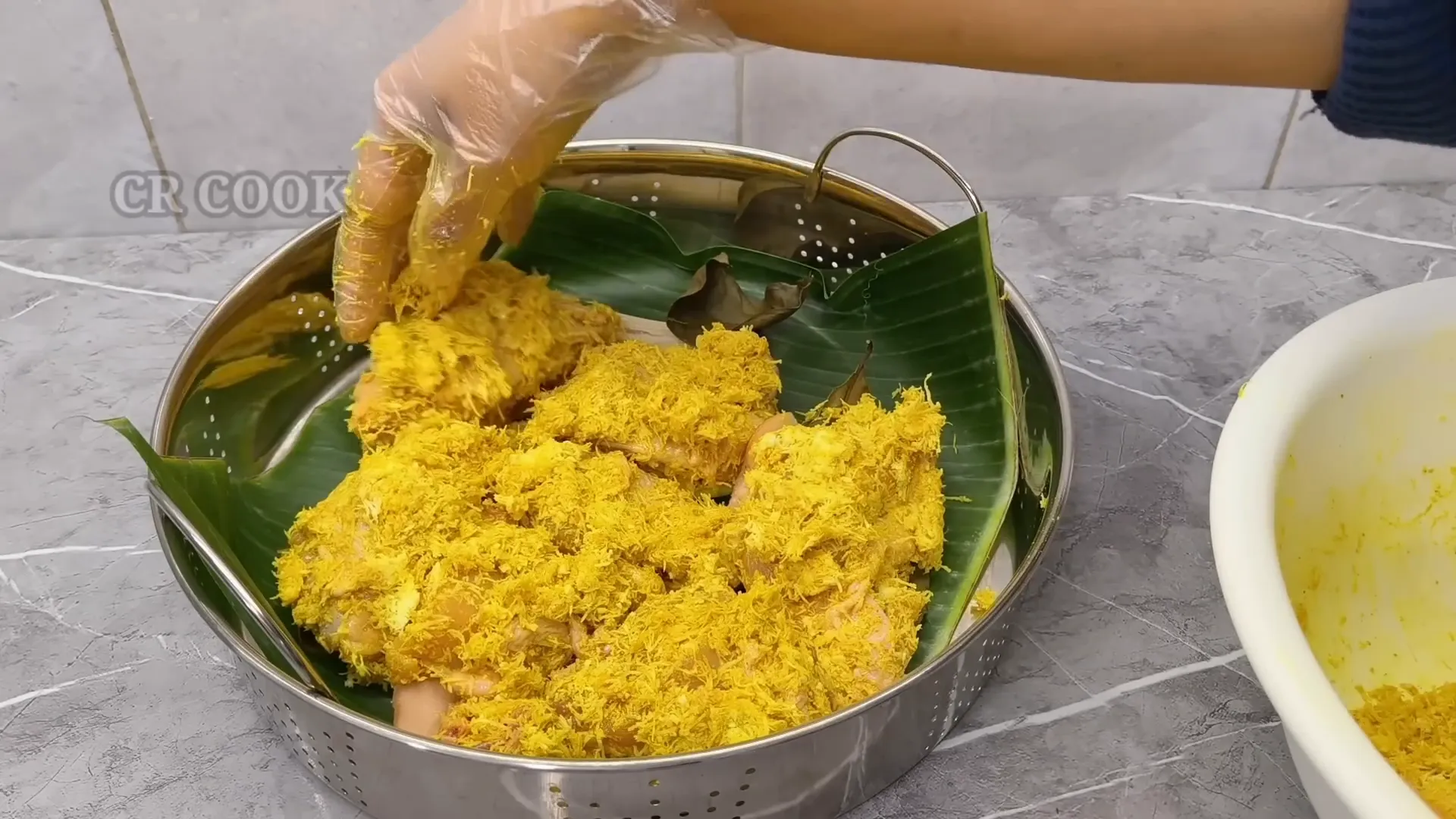 Ayam dimasukkan ke dalam kukusan yang dilapisi daun pisang dan aromatik