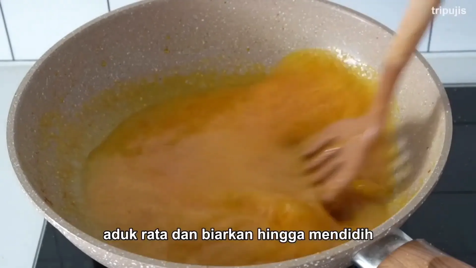 Menunjukkan tumisan bumbu dan bahan kuah pedas untuk ikan nila