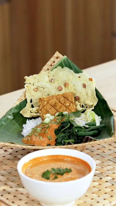 Pecel siap disajikan dengan tempe goreng, kemangi, dan timun