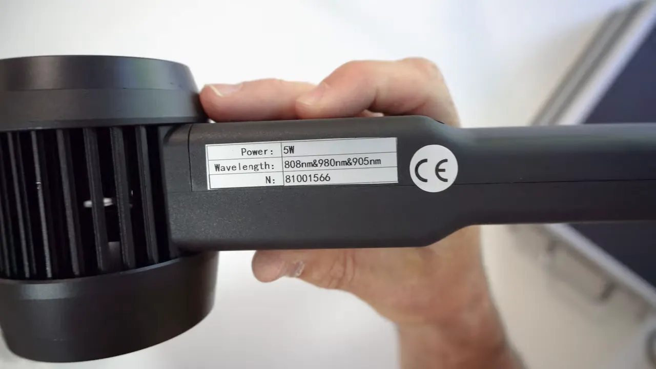 Close up of handheld laser label listing power and wavelengths including 808nm and 905nm