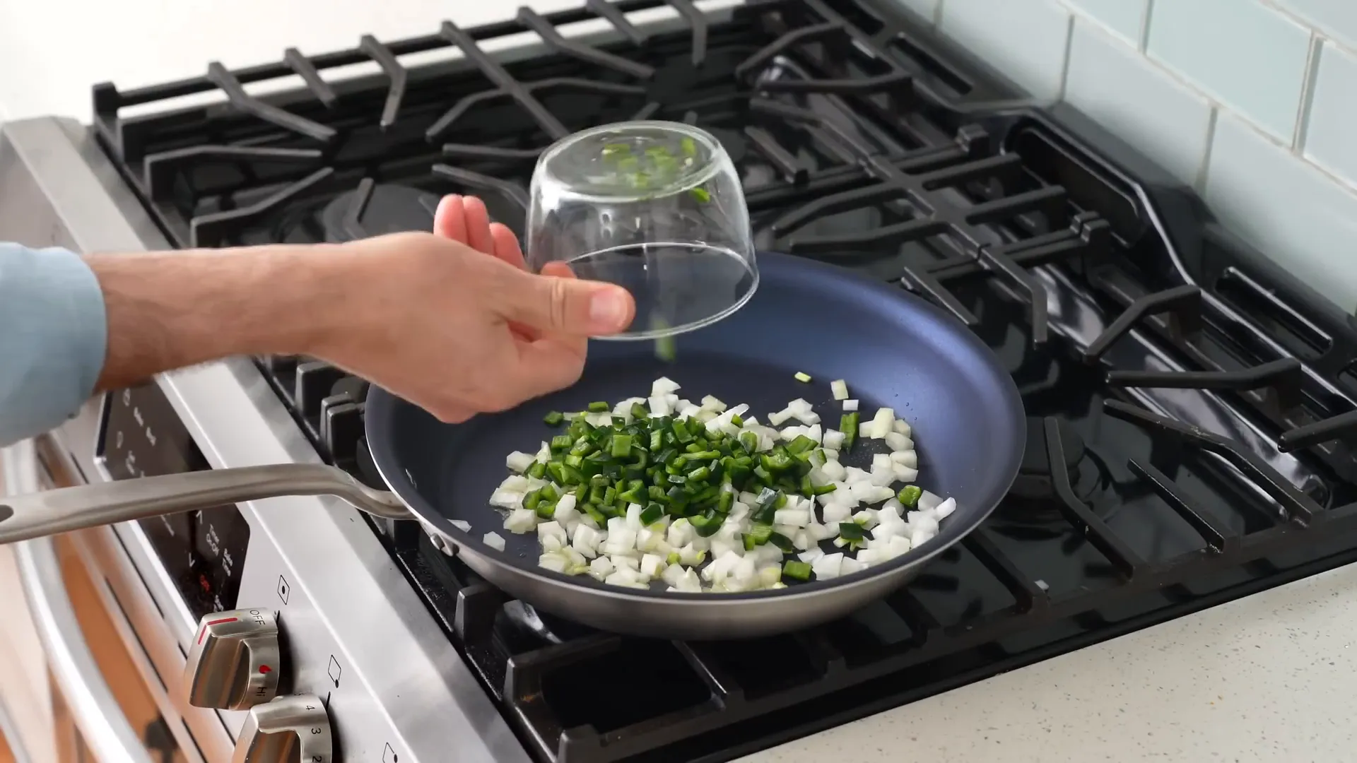 Adding onions and poblanos to the pan