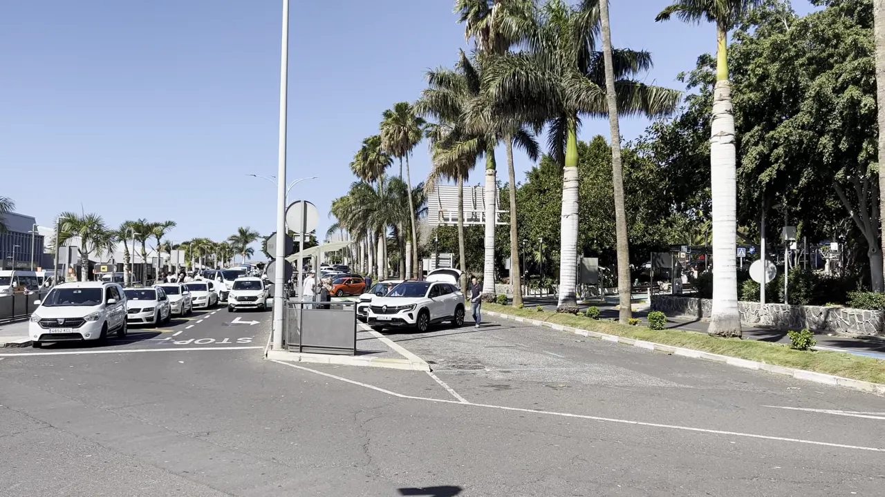 Tenerife South Airport guide - arrivals, departures, taxis, buses and car hire 6 Departures drop-off zone at Tenerife South Airport with parked cars, taxis and a passenger walking to a vehicle