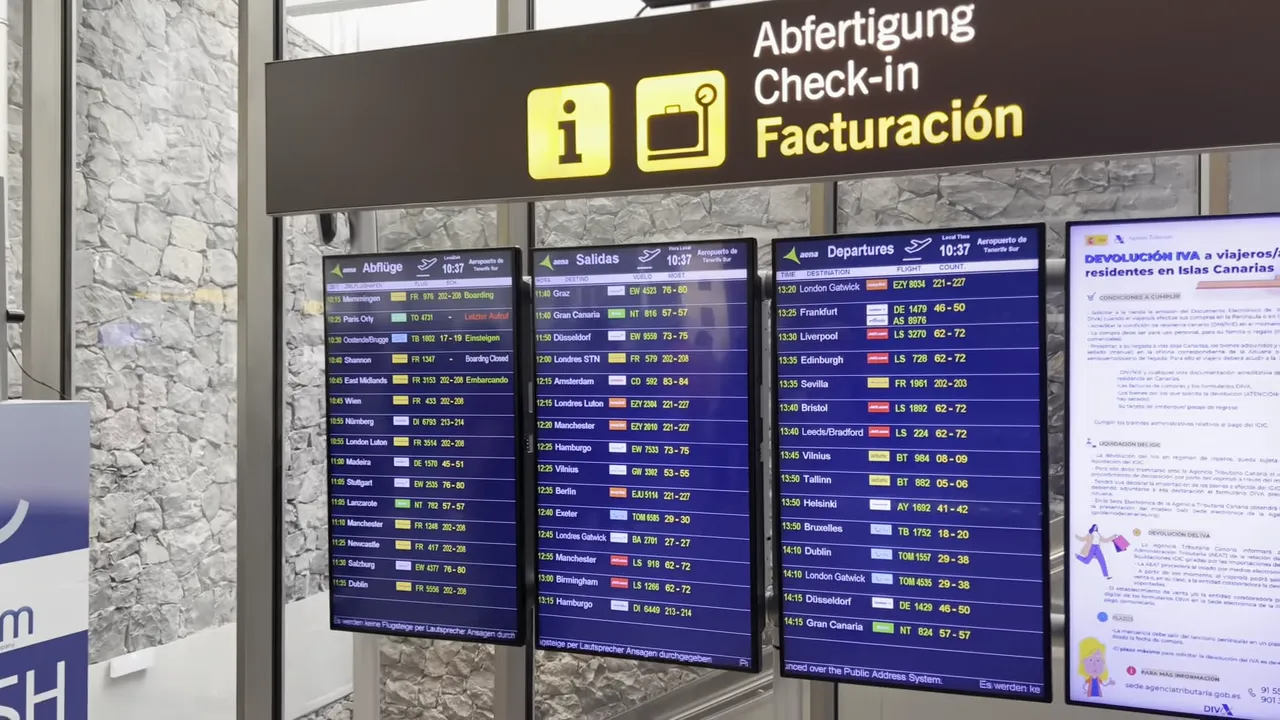Tenerife South Airport guide - arrivals, departures, taxis, buses and car hire 7 Clear, high-resolution shot of 'Check-in Facturación' signage and four digital departure boards at Tenerife South Airport