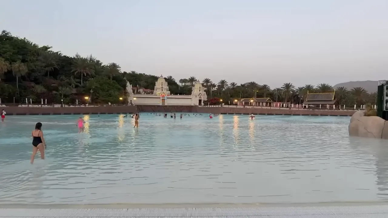 Piscine à vagues au crépuscule avec scène éclairée et reflets sur l'eau