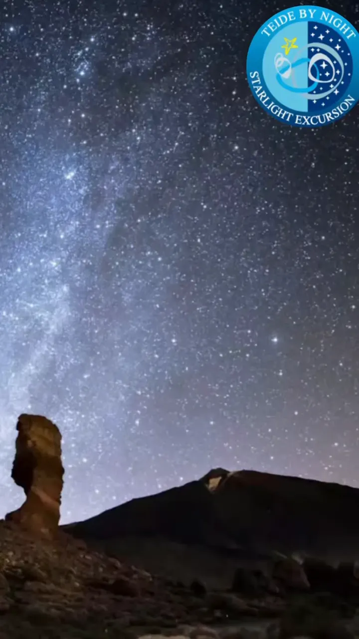 Nocne niebo usiane gwiazdami nad ciemną sylwetką góry w Parku Narodowym Teide