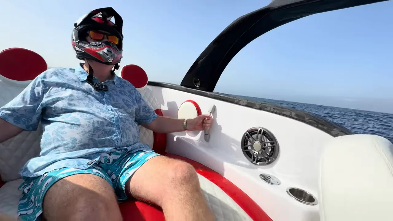 Passenger seated on the Fiat 500 Abarth speed boat wearing a helmet with open ocean ahead