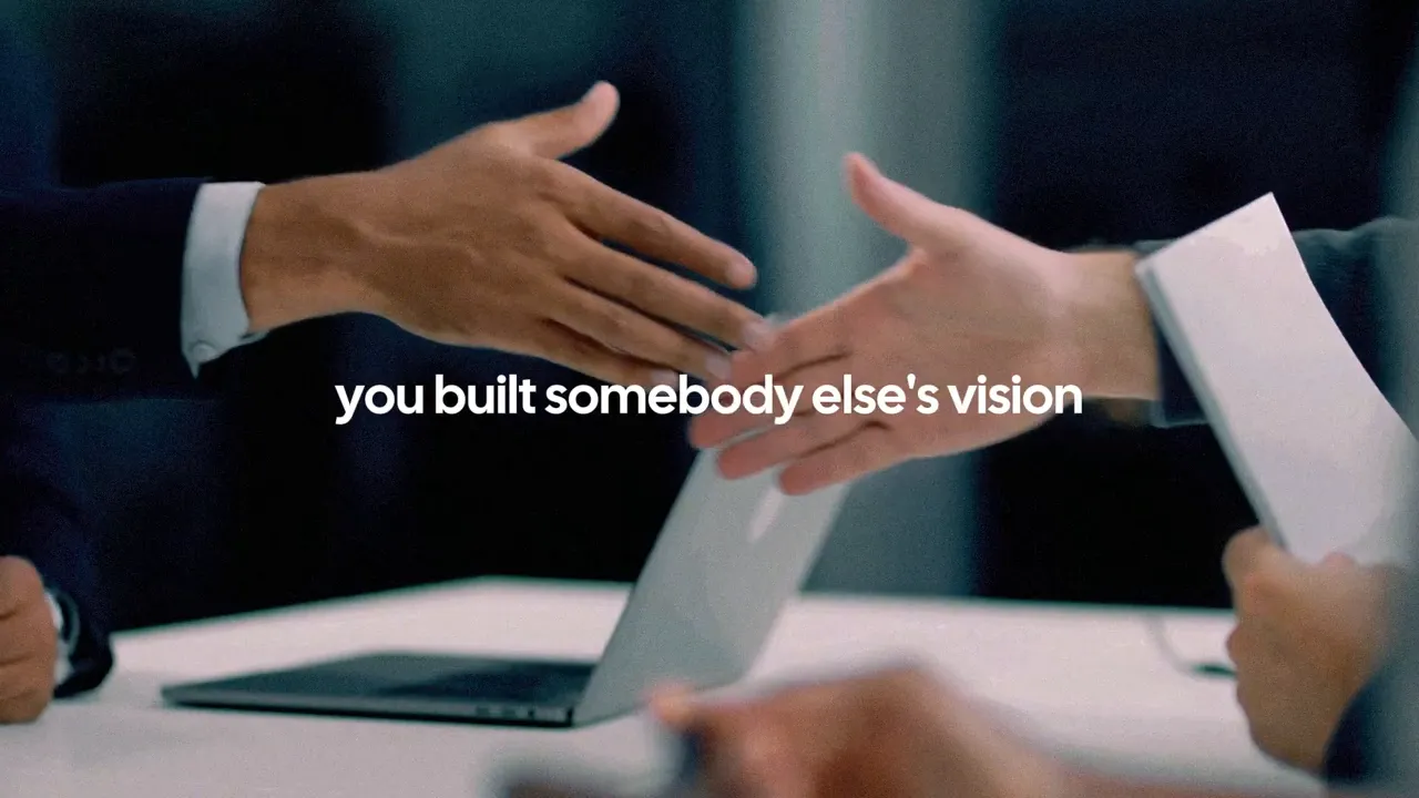 two people reaching to shake hands over a table with a laptop and the text 'you built somebody else's vision' visible