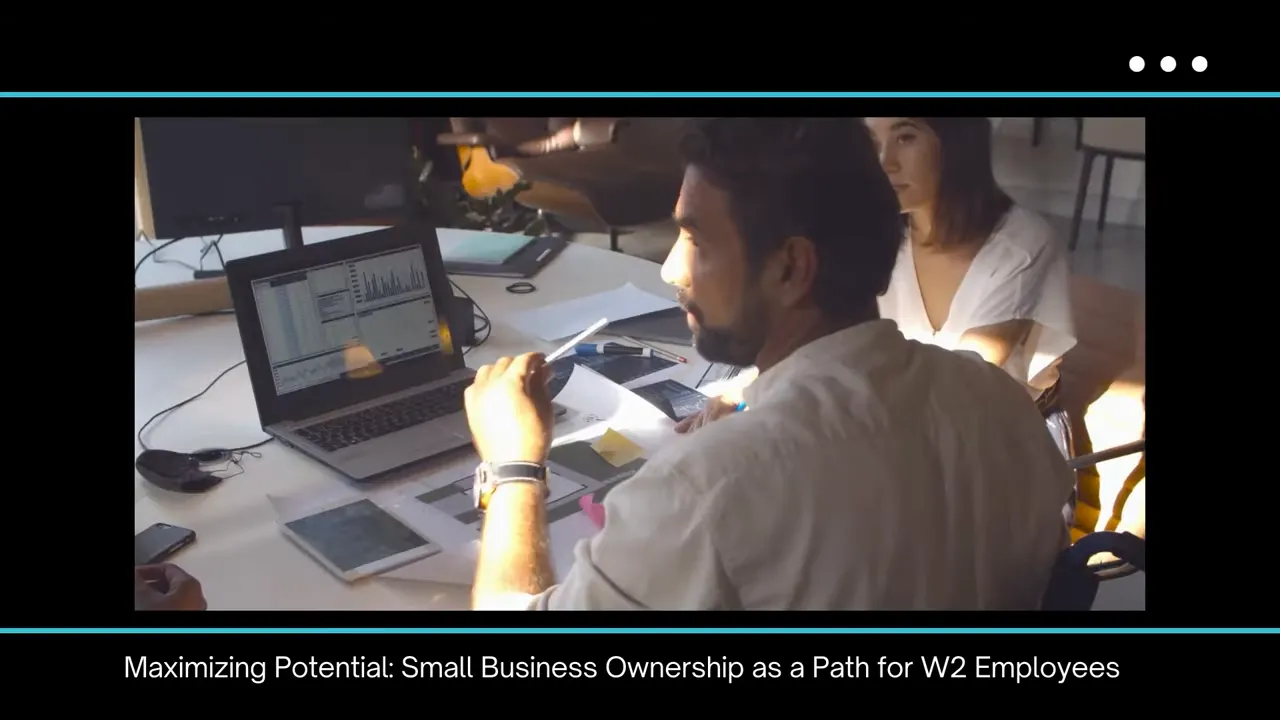 People around a table looking at a laptop showing charts and papers, reviewing business data and documents.