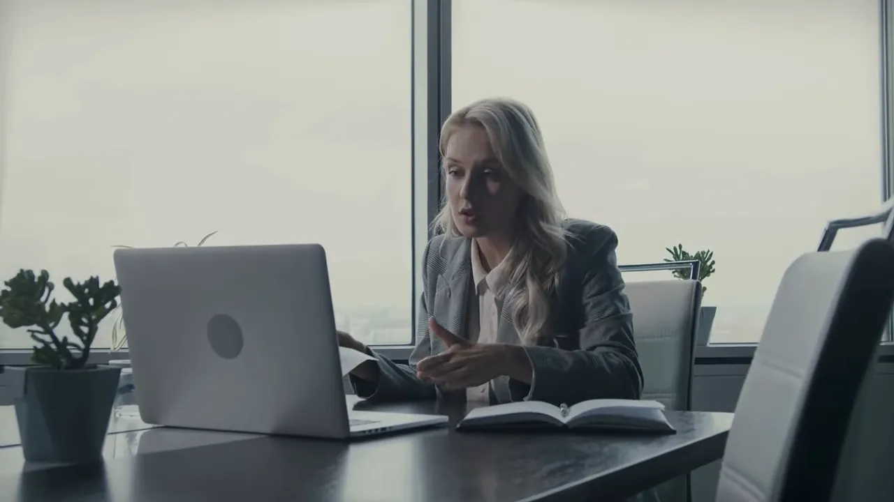Person reviewing documents and a laptop in a conference room
