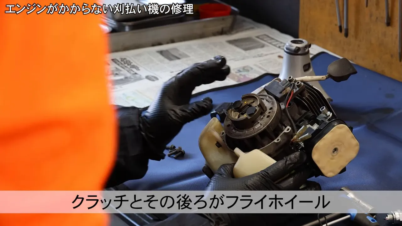 クラッチとフライホイール、イグニッションコイルが露出した刈払い機のエンジン部分の鮮明な画像