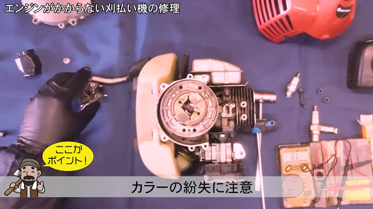 取り外した部品を手に持ち、コイルや小さなカラーの位置を確認している作業ショット。画面下に注意テロップあり。