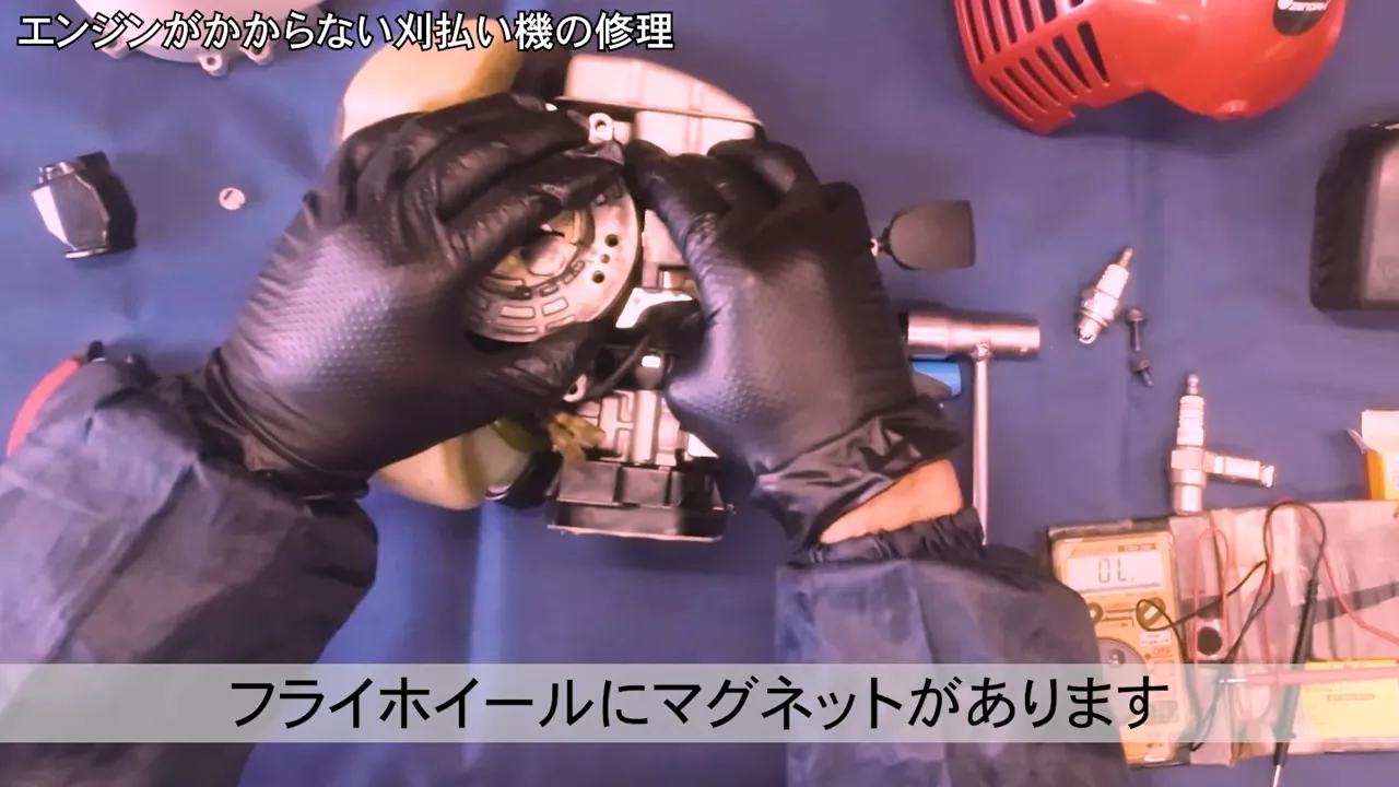 刈払機のフライホイールとイグニッションコイルの隙間を手で調整しているアップショット